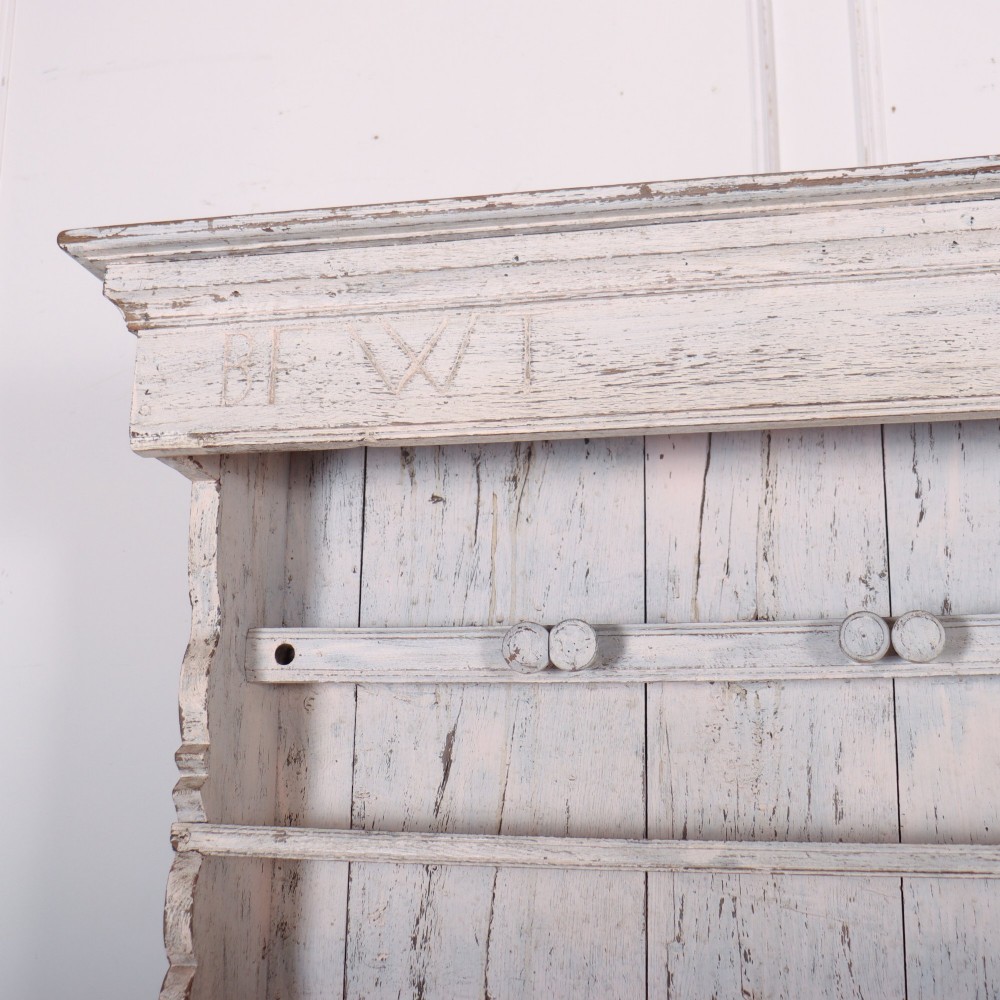 An antique off-white painted Danish pine dresser featuring an open tiered plate rack above a three-door cupboard base with diamond-moulded panels. View IV