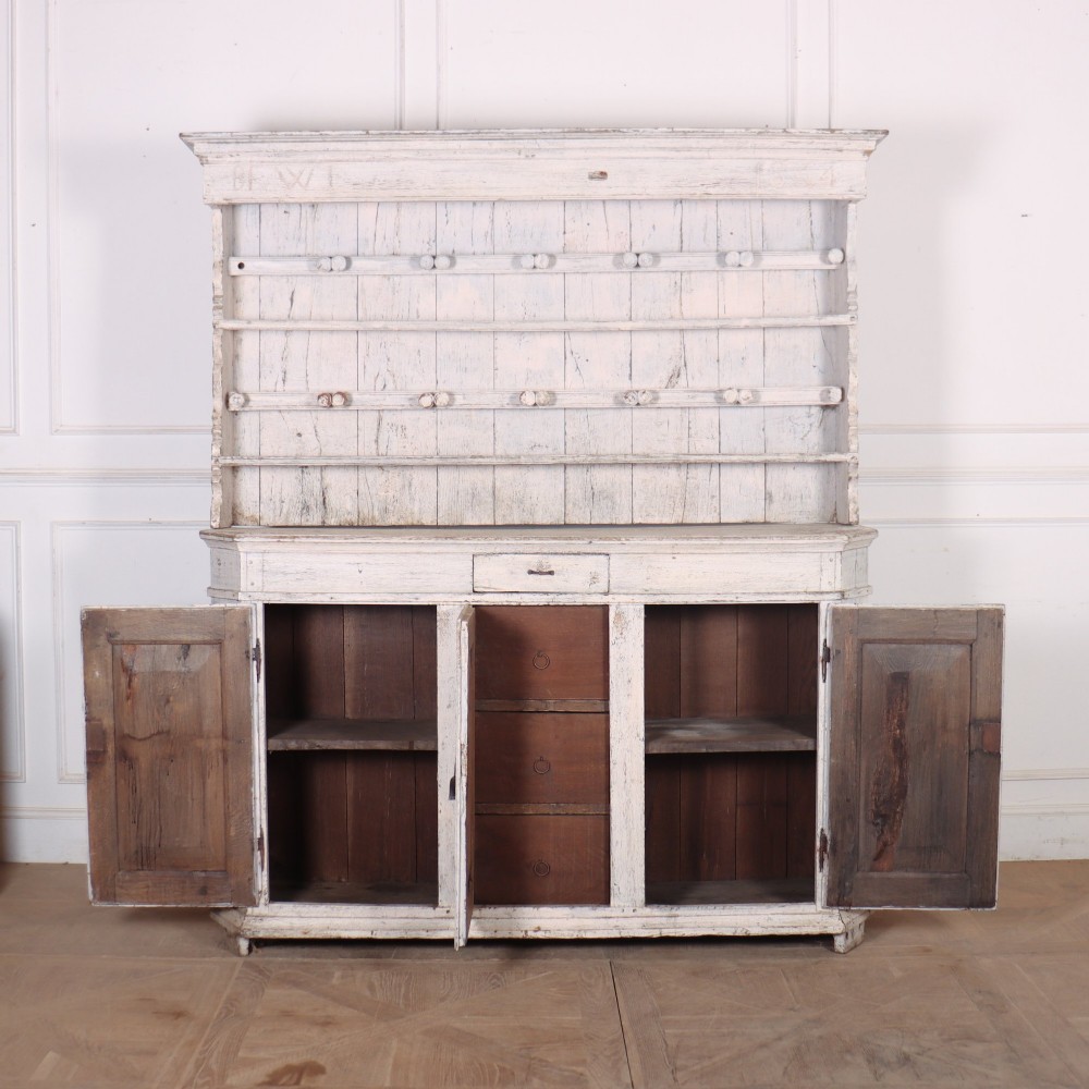 An antique off-white painted Danish pine dresser featuring an open tiered plate rack above a three-door cupboard base with diamond-moulded panels. View VIII