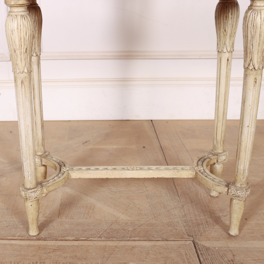 An oval cream painted antique jardiniere table featuring a pierced baluster gallery rim, slender carved legs, and a lower curved stretcher base. View III