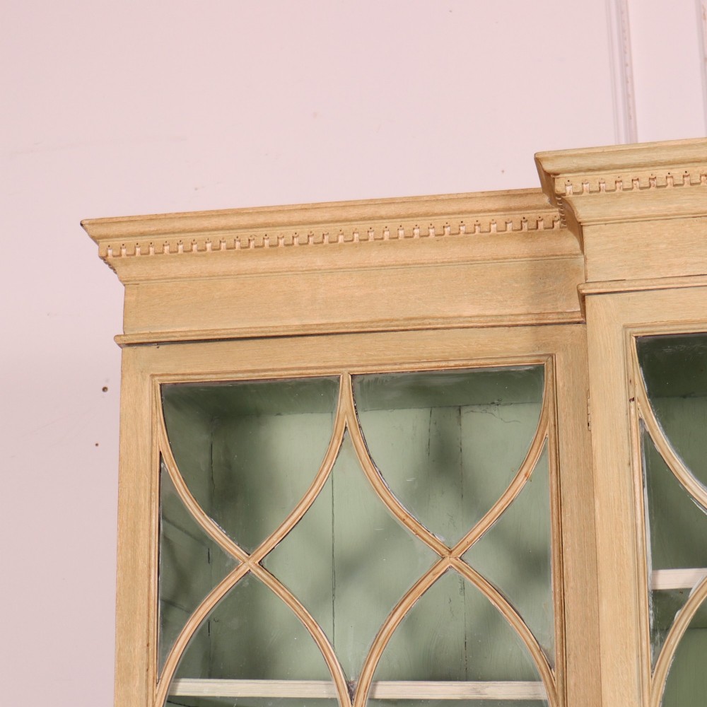 A nineteenth-century painted breakfront secretaire bookcase featuring upper Gothic astragal glazed doors over a green interior backdrop, above lower drawers and panelled cupboard doors. View II