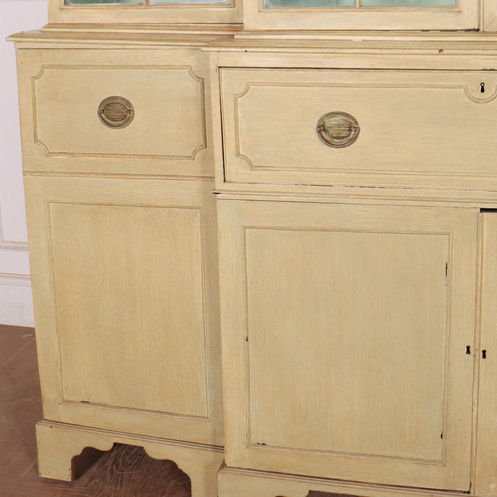 A nineteenth-century painted breakfront secretaire bookcase featuring upper Gothic astragal glazed doors over a green interior backdrop, above lower drawers and panelled cupboard doors. View IV
