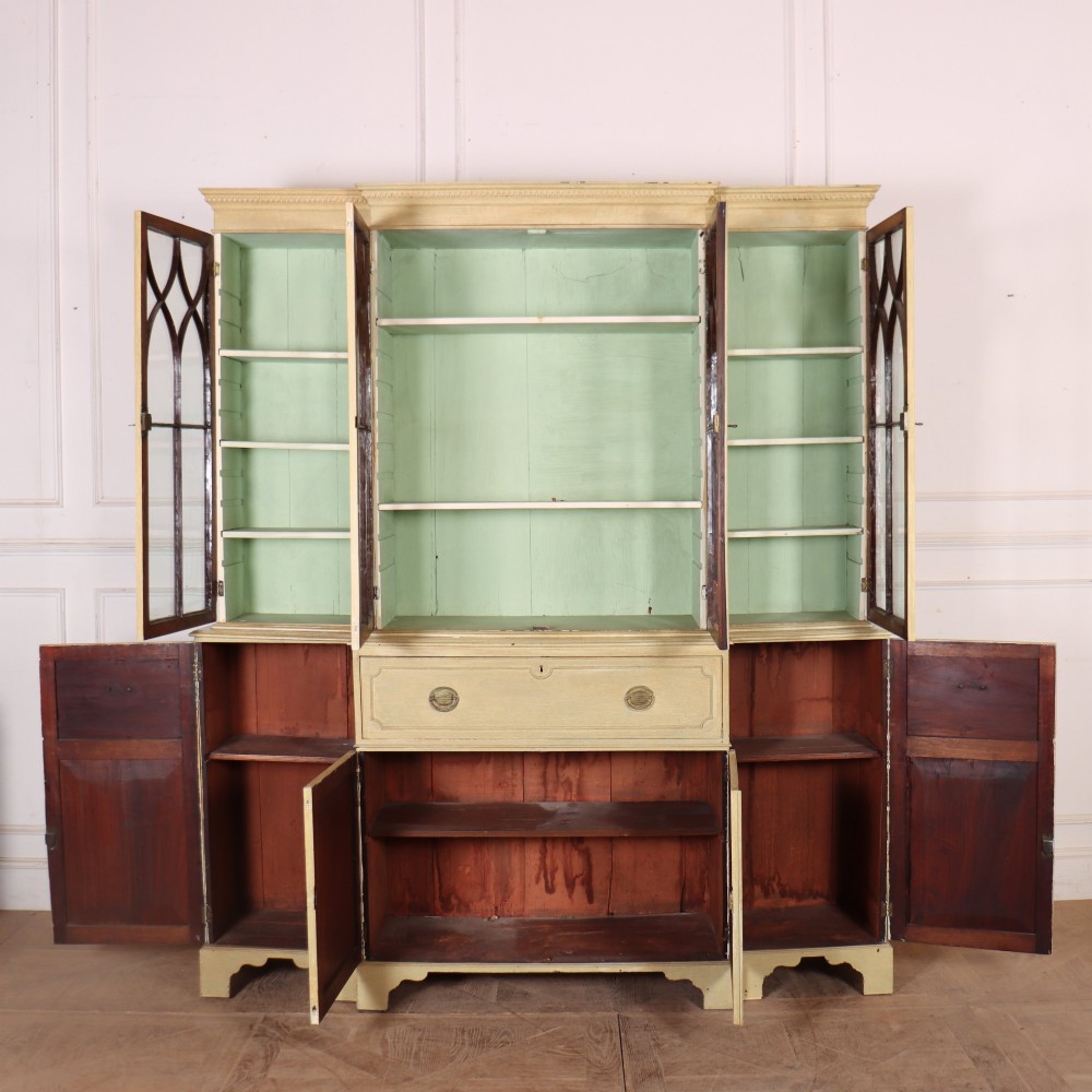 A nineteenth-century painted breakfront secretaire bookcase featuring upper Gothic astragal glazed doors over a green interior backdrop, above lower drawers and panelled cupboard doors. View VI