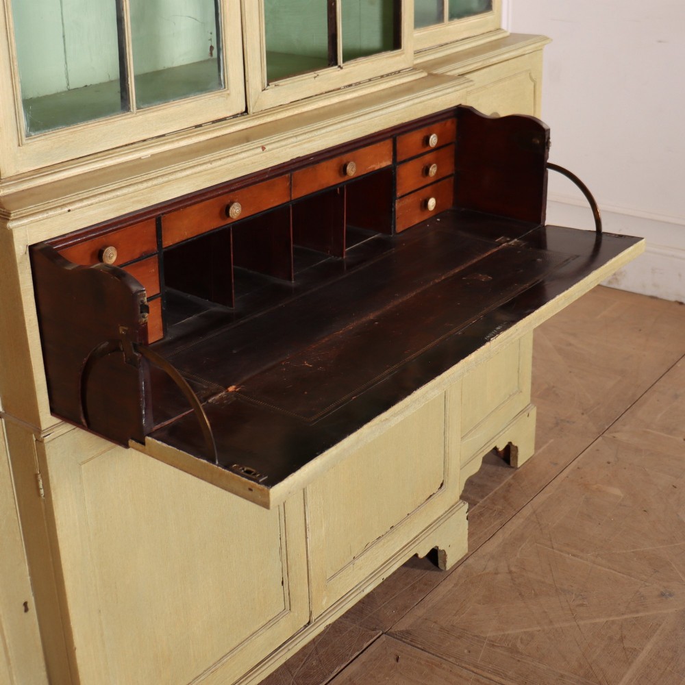 A nineteenth-century painted breakfront secretaire bookcase featuring upper Gothic astragal glazed doors over a green interior backdrop, above lower drawers and panelled cupboard doors. View VIII
