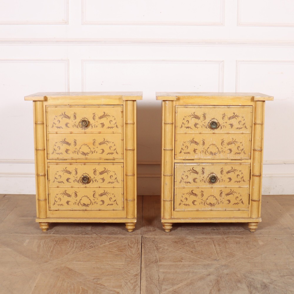A pair of 19th-century pale yellow painted bedside cabinets featuring turned faux bamboo corner columns and hand-painted foliate motifs.