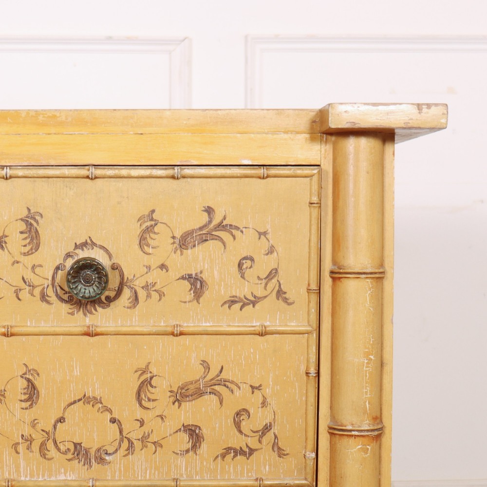 A pair of 19th-century pale yellow painted bedside cabinets featuring turned faux bamboo corner columns and hand-painted foliate motifs. View VI