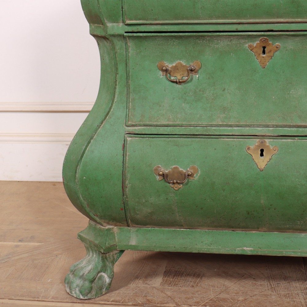 A green painted Dutch bombe commode with three drawers, brass drop handles, keyhole escutcheons, and carved feet. View V
