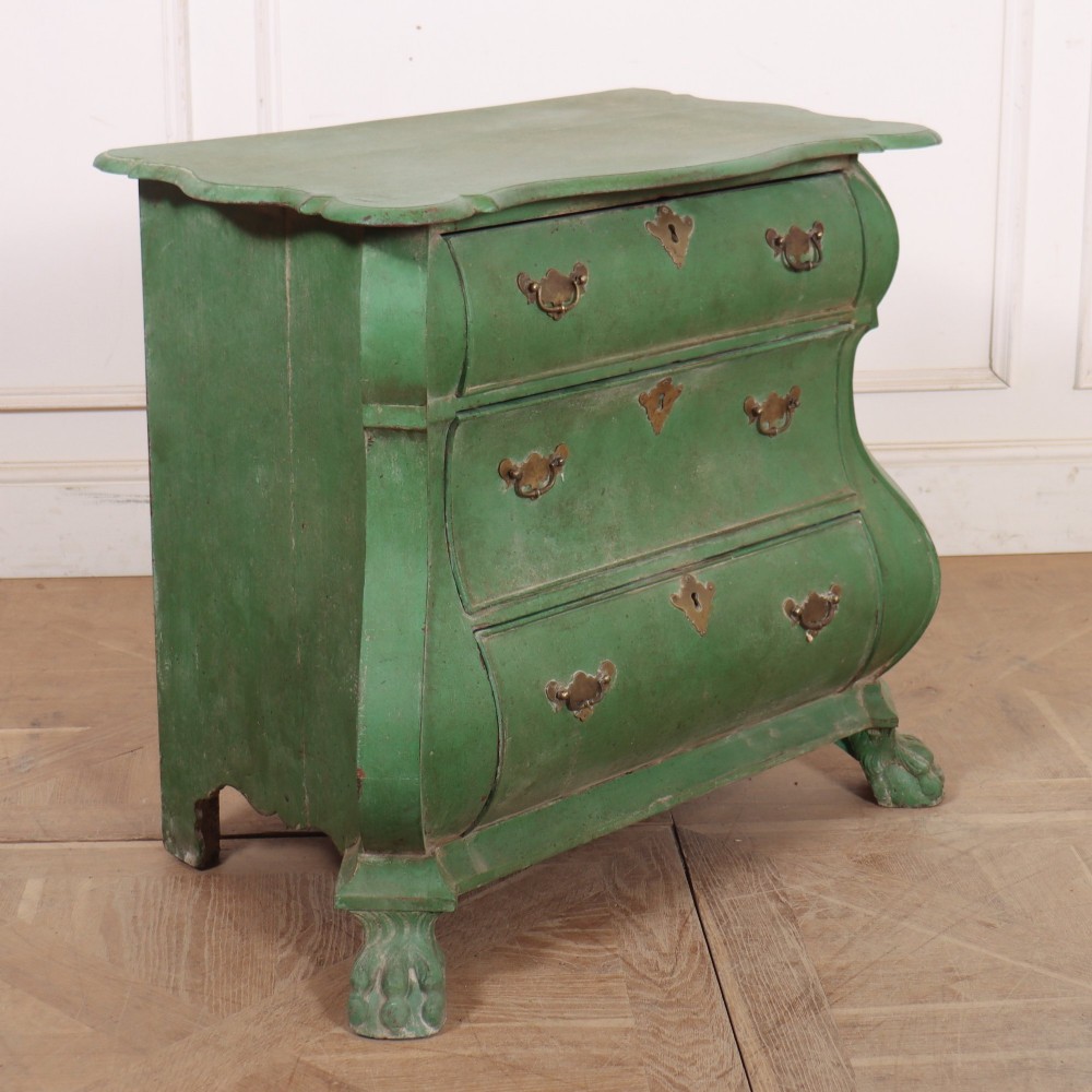 A green painted Dutch bombe commode with three drawers, brass drop handles, keyhole escutcheons, and carved feet. View VI