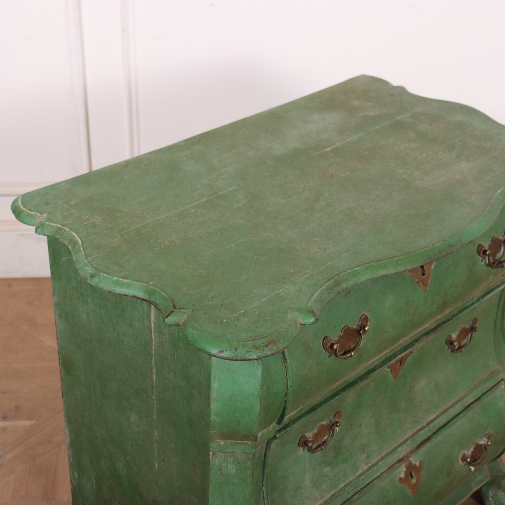 A green painted Dutch bombe commode with three drawers, brass drop handles, keyhole escutcheons, and carved feet. View VIII