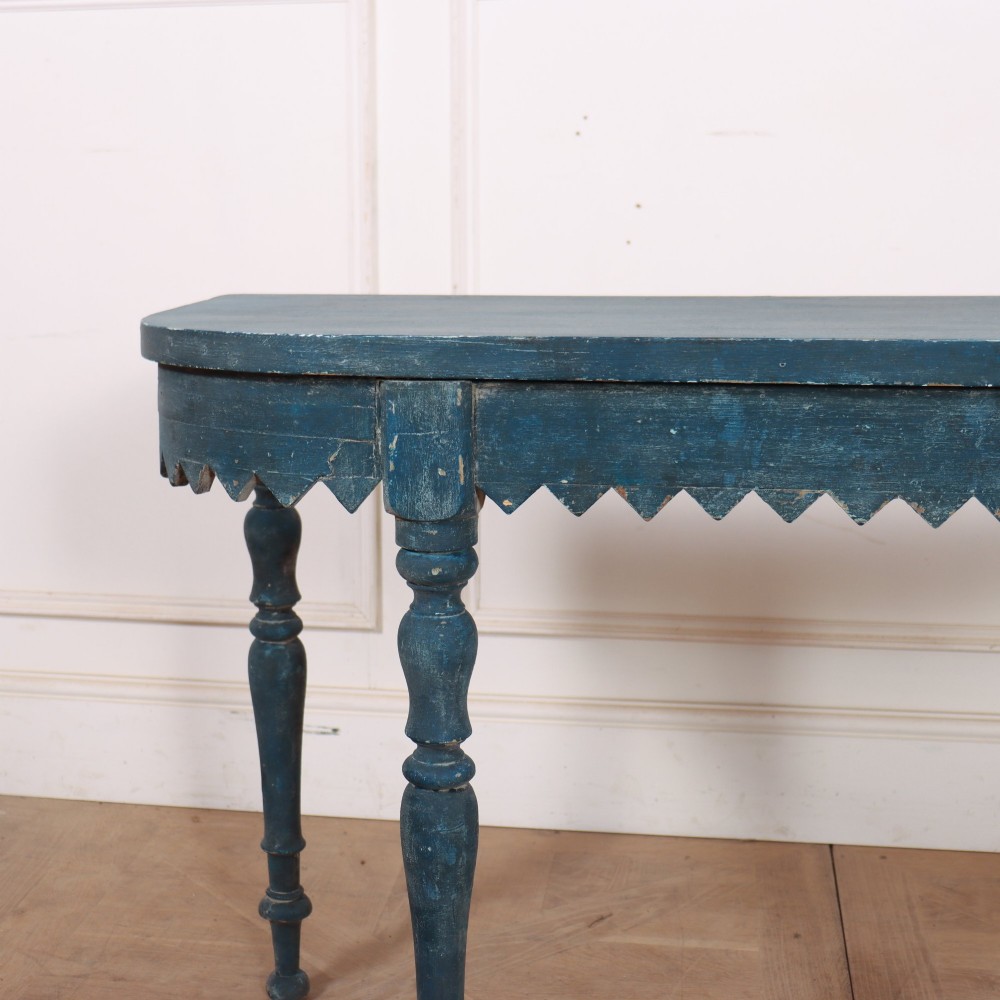 A blue painted wooden console table featuring rounded bow ends, a scalloped apron, and four turned legs. View II