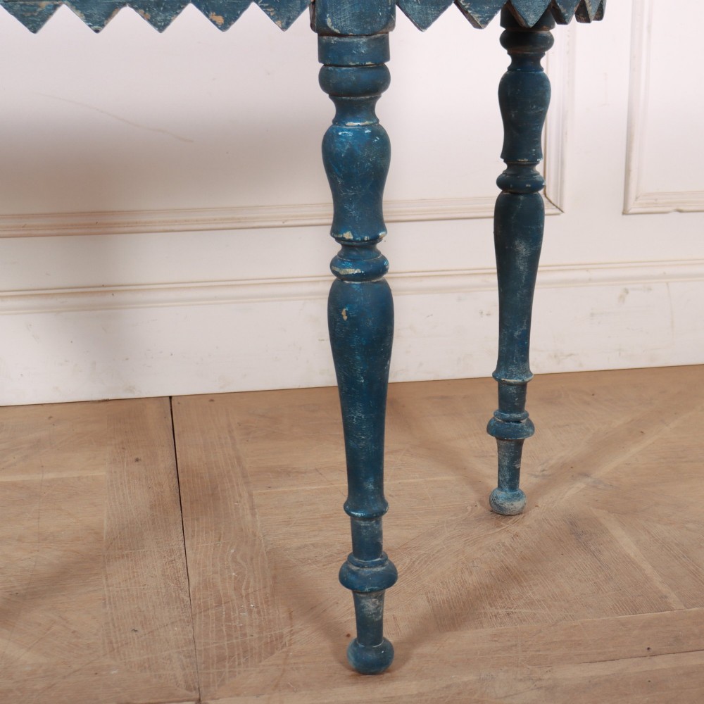 A blue painted wooden console table featuring rounded bow ends, a scalloped apron, and four turned legs. View IV