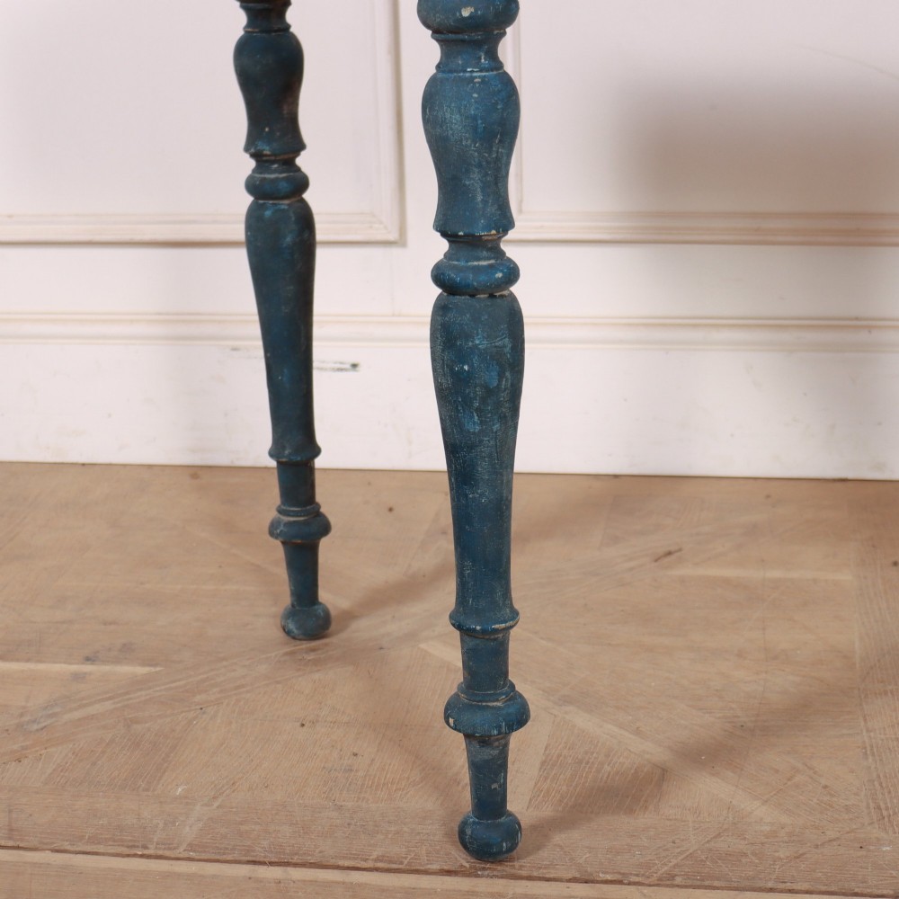 A blue painted wooden console table featuring rounded bow ends, a scalloped apron, and four turned legs. View V