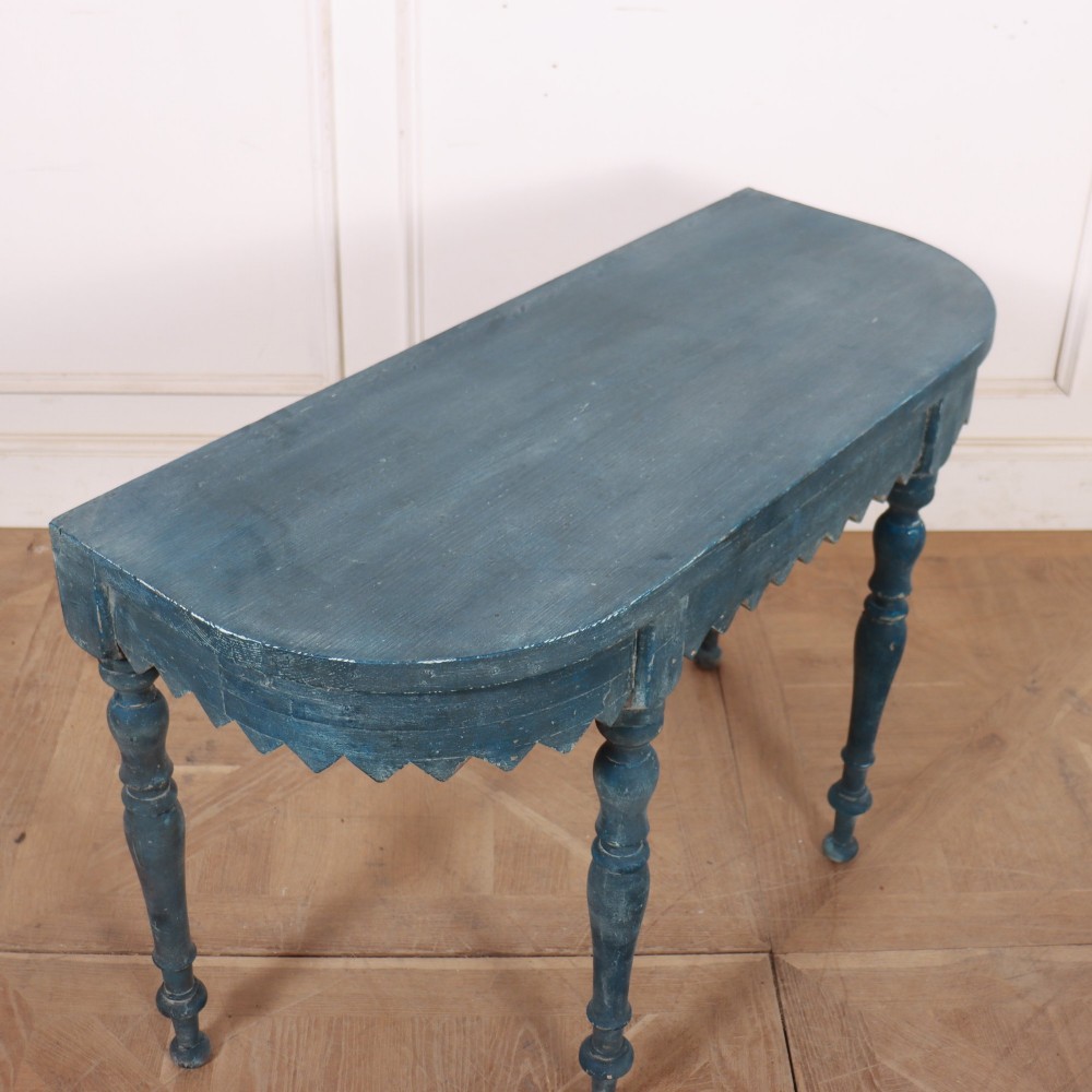 A blue painted wooden console table featuring rounded bow ends, a scalloped apron, and four turned legs. View VI
