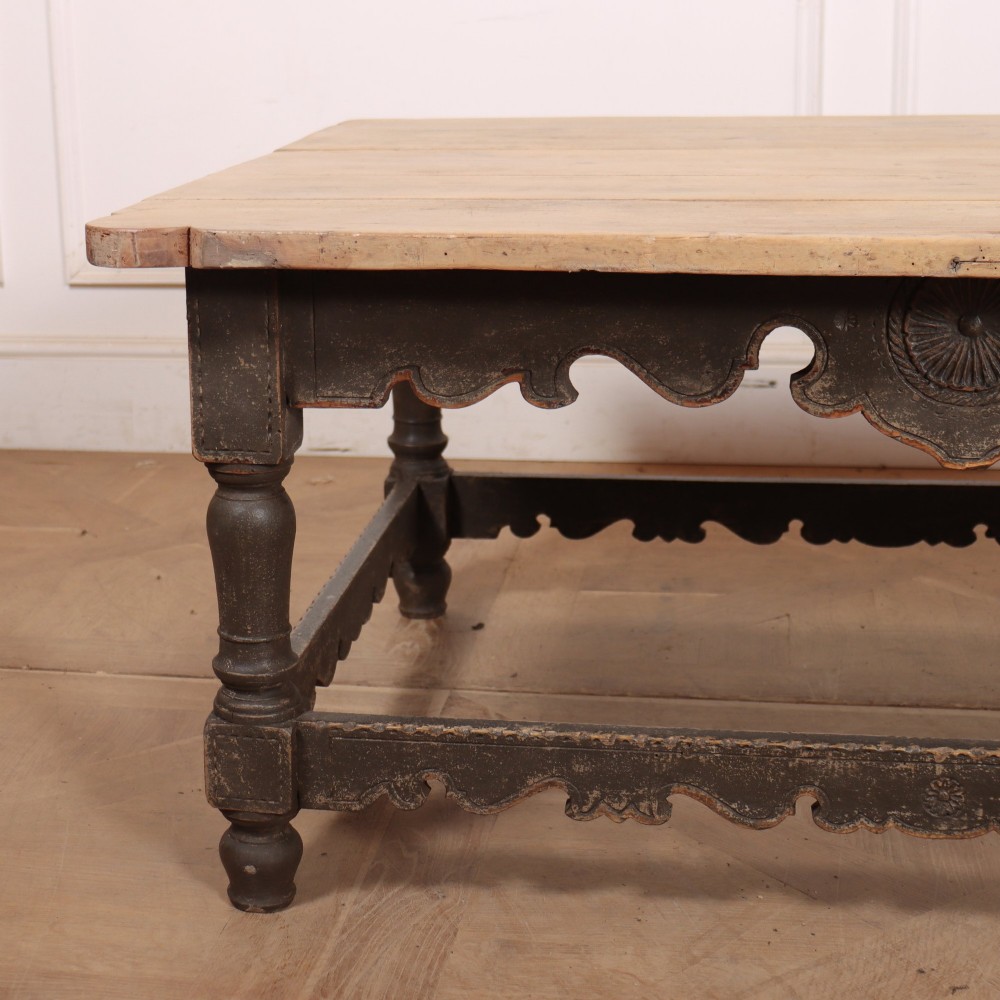 A low rectangular coffee table with a scrubbed pine top and dark painted frame featuring scalloped aprons, a carved shell motif, and turned legs. View II