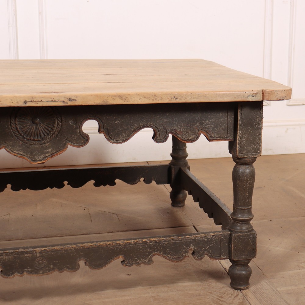 A low rectangular coffee table with a scrubbed pine top and dark painted frame featuring scalloped aprons, a carved shell motif, and turned legs. View III