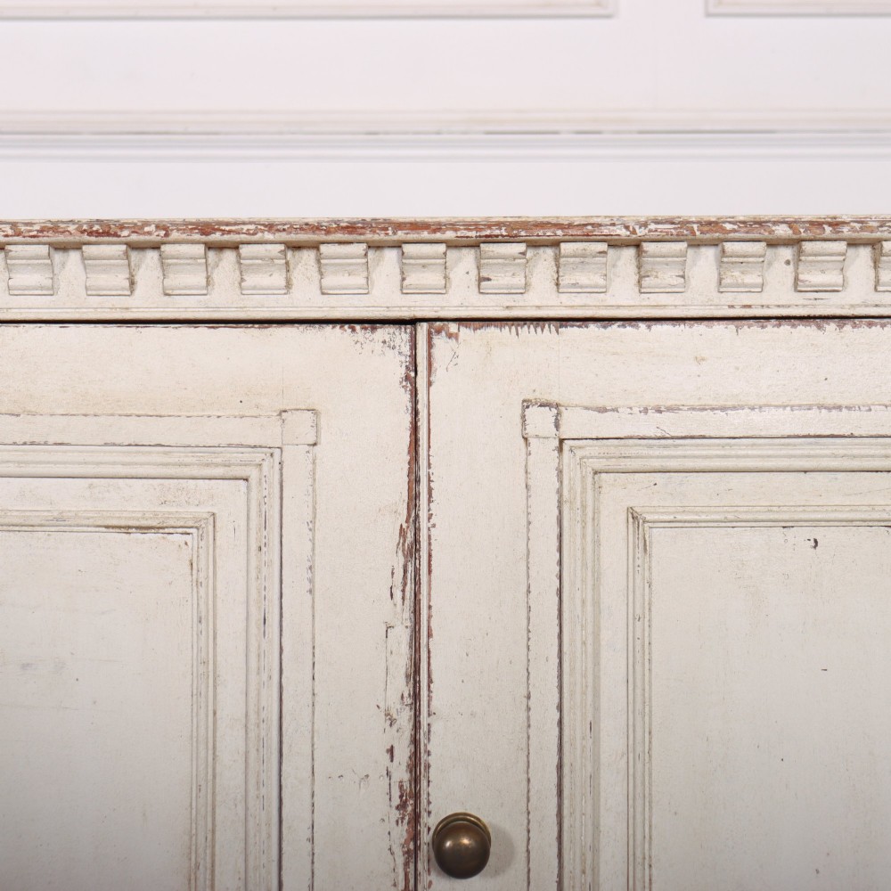 A long four-door Italian painted wooden enfilade with a distressed off-white finish, moulded cupboard panels, and bracket feet. View V