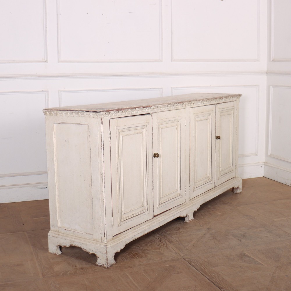 A long four-door Italian painted wooden enfilade with a distressed off-white finish, moulded cupboard panels, and bracket feet. View VIII