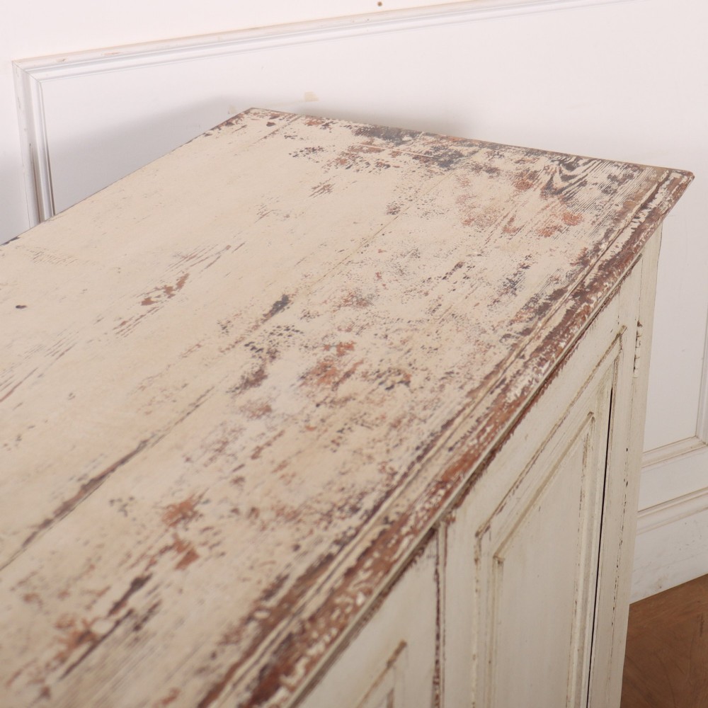 A long four-door Italian painted wooden enfilade with a distressed off-white finish, moulded cupboard panels, and bracket feet. View XI