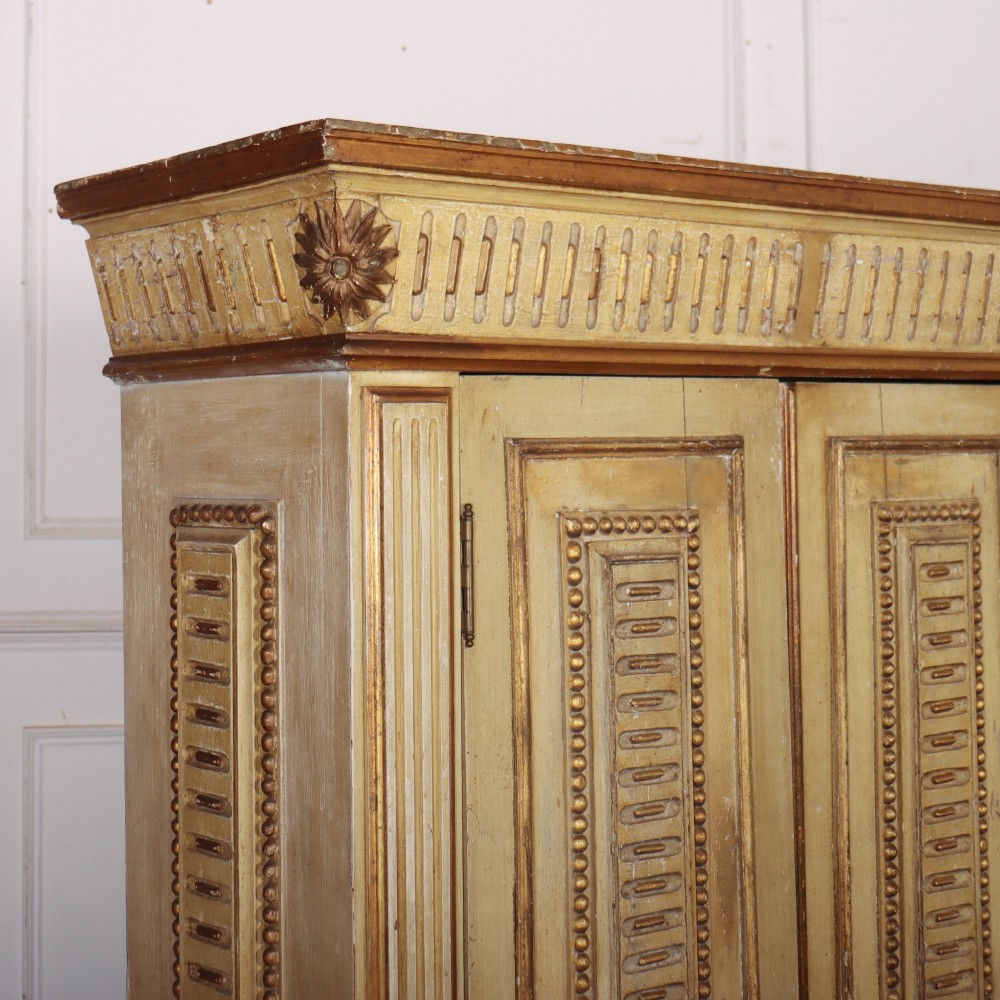 A late nineteenth-century Italian painted and gilded wooden cupboard featuring two tall doors with decorative carved panels, flanked by fluted pilasters on bun feet. View IX
