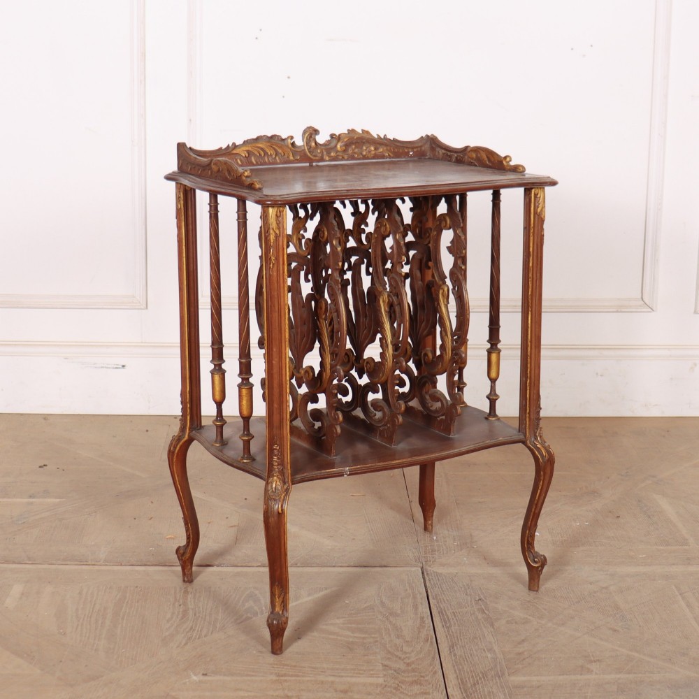 An antique French Rococo style wooden folio stand featuring carved openwork dividers, turned side spindles, cabriole legs, and parcel gilt detailing.