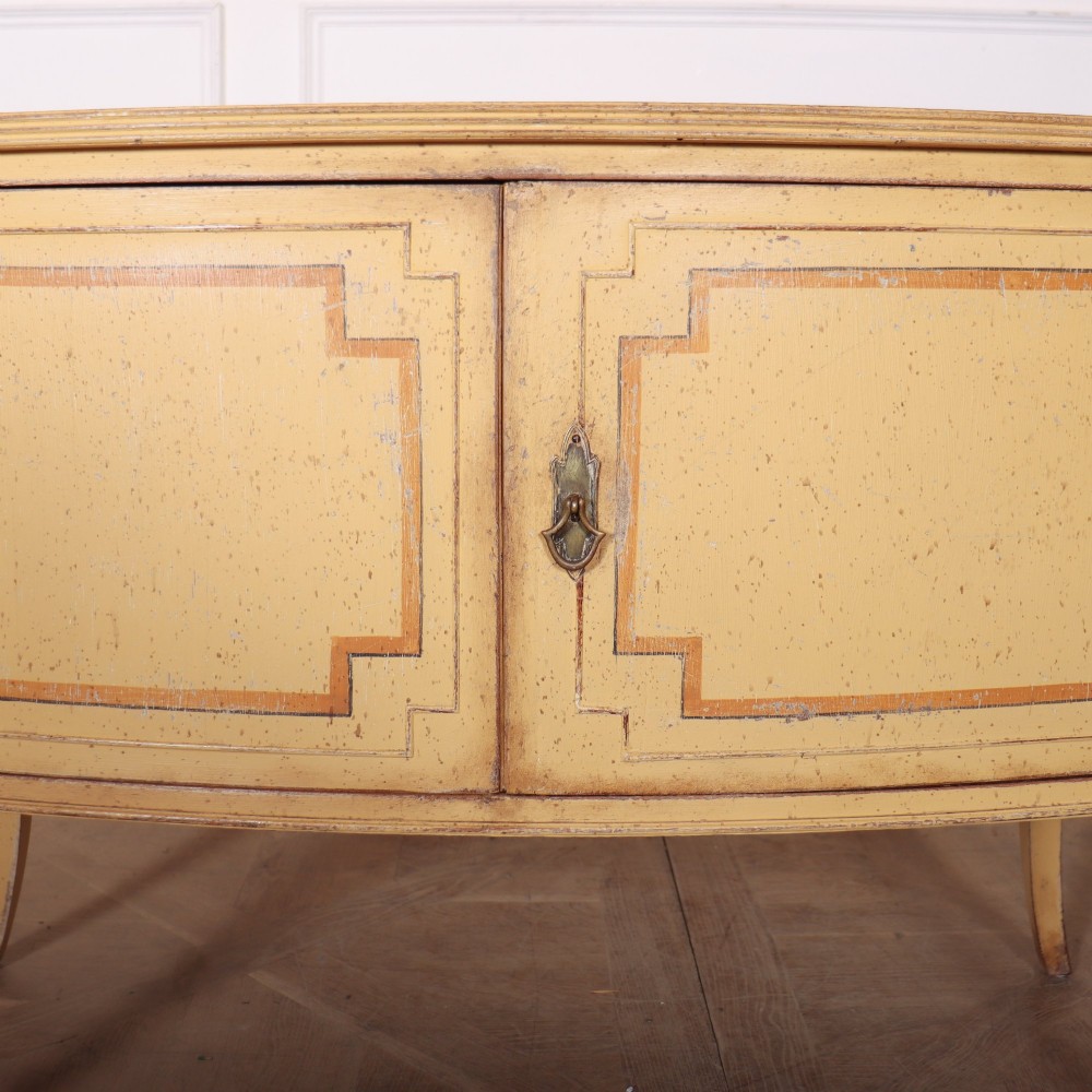 An antique English painted side cabinet in pale yellow with geometric orange door borders and tapered legs. View VII