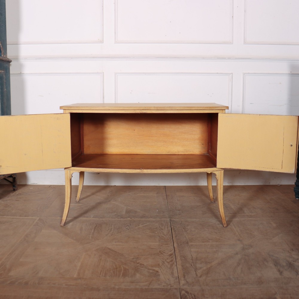 An antique English painted side cabinet in pale yellow with geometric orange door borders and tapered legs. View VIII