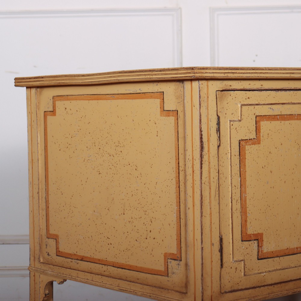 An antique English painted side cabinet in pale yellow with geometric orange door borders and tapered legs. View XI