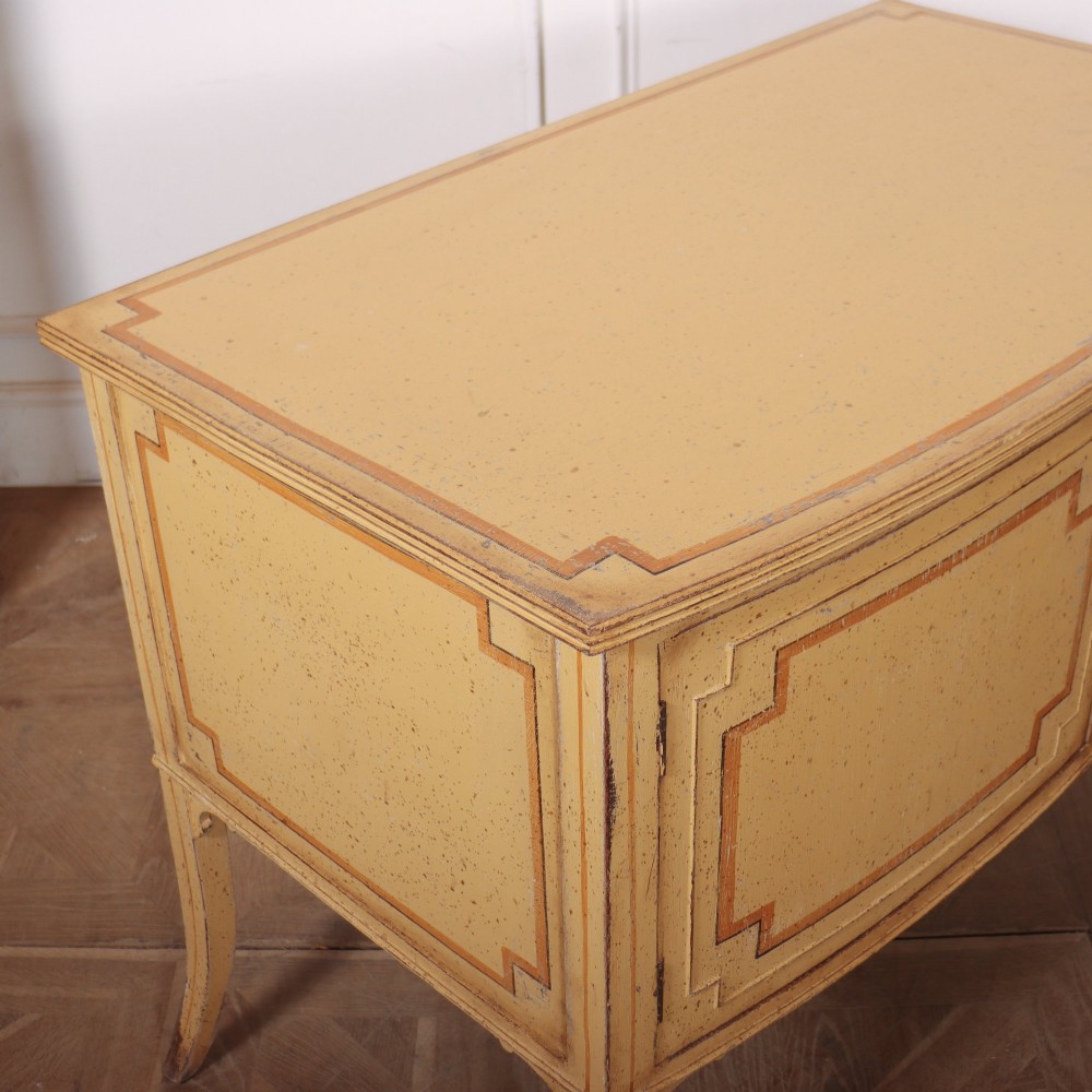 An antique English painted side cabinet in pale yellow with geometric orange door borders and tapered legs. View XII