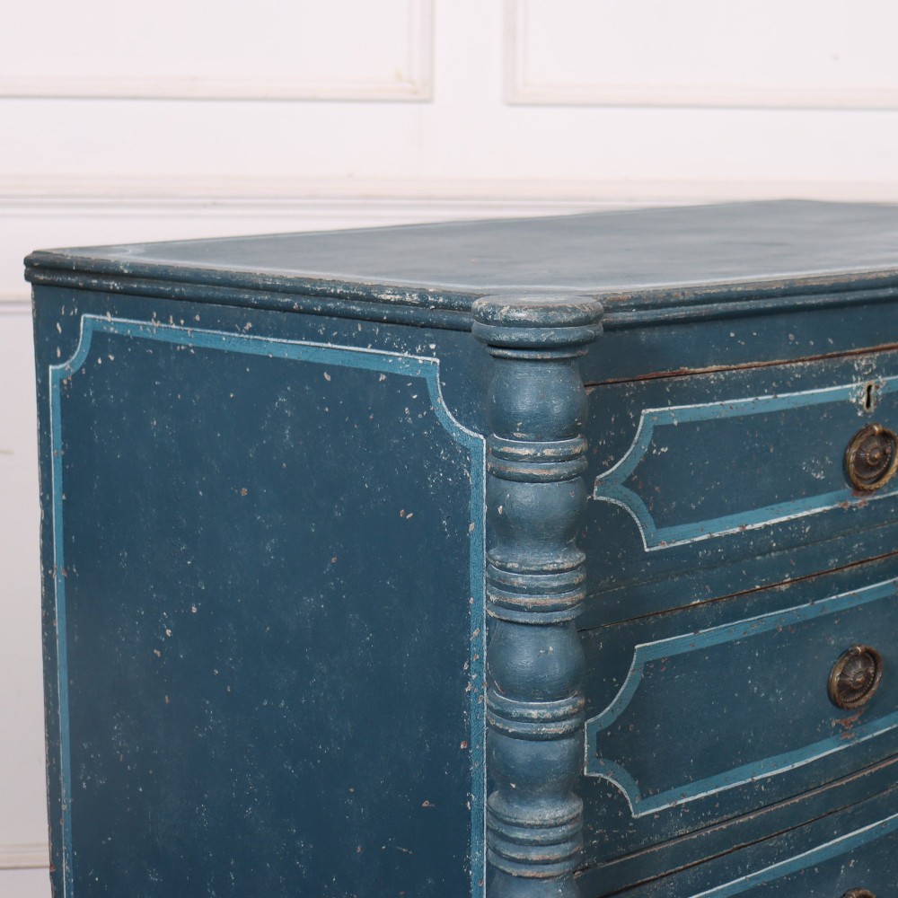 An antique English bowfront chest of drawers with a distressed blue painted finish, painted line borders, and bobbin-turned columns. View VIII