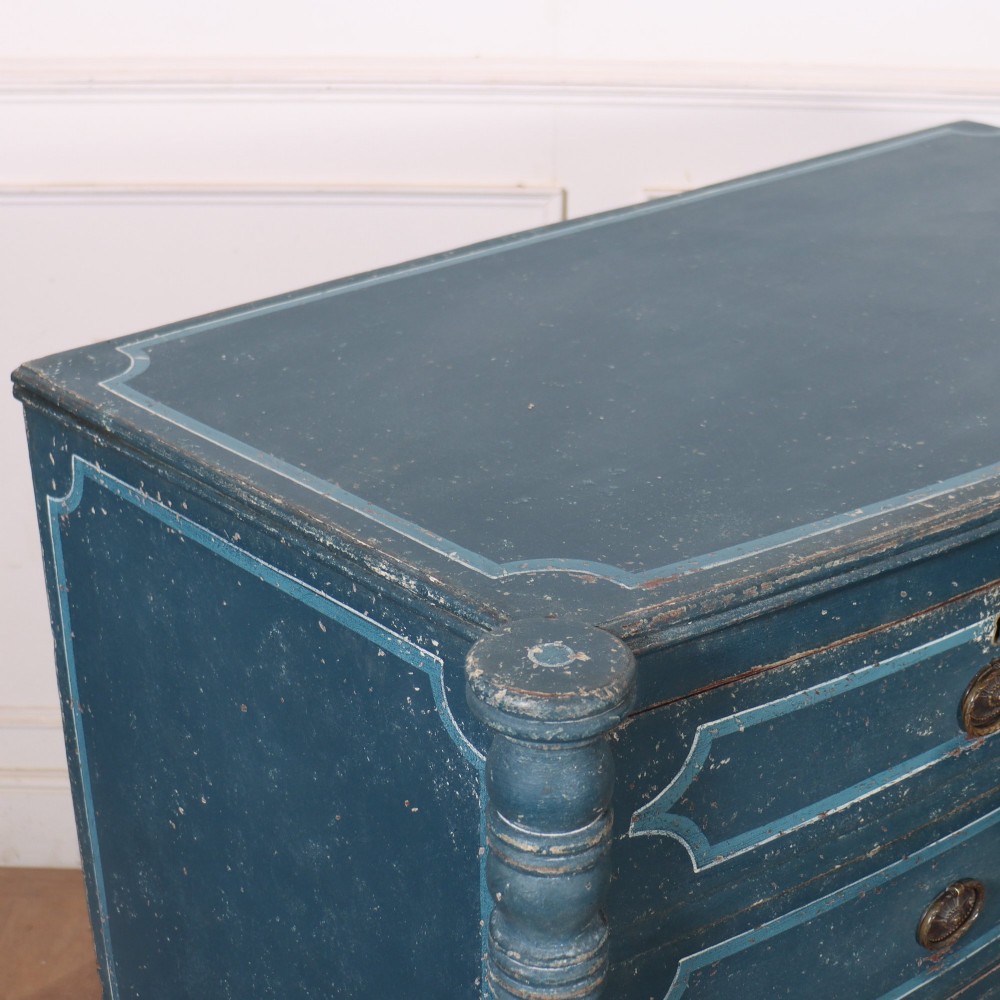 An antique English bowfront chest of drawers with a distressed blue painted finish, painted line borders, and bobbin-turned columns. View IX