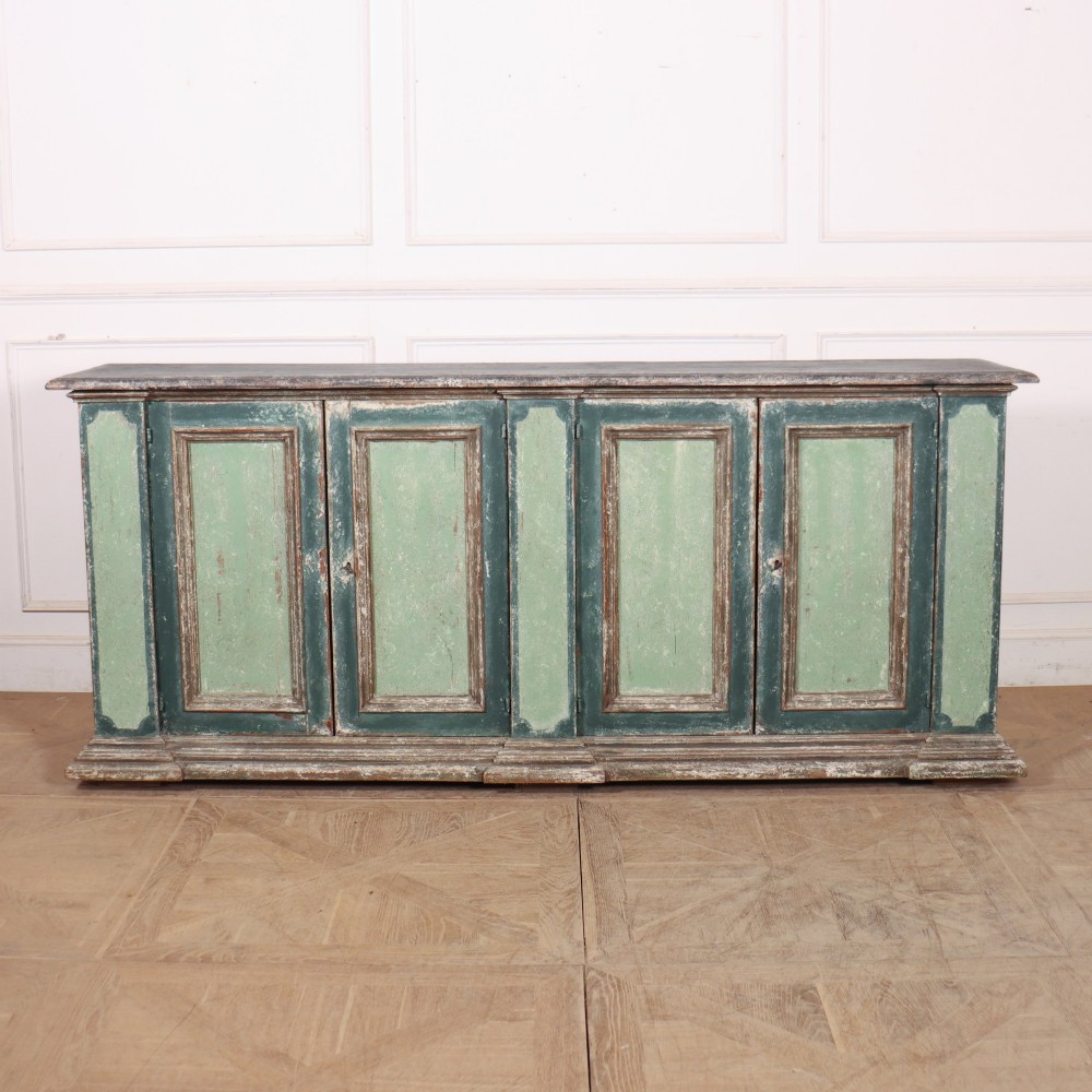 A long rectangular antique Italian side cabinet featuring four panelled doors in a distressed sage and teal painted finish with a plinth base.