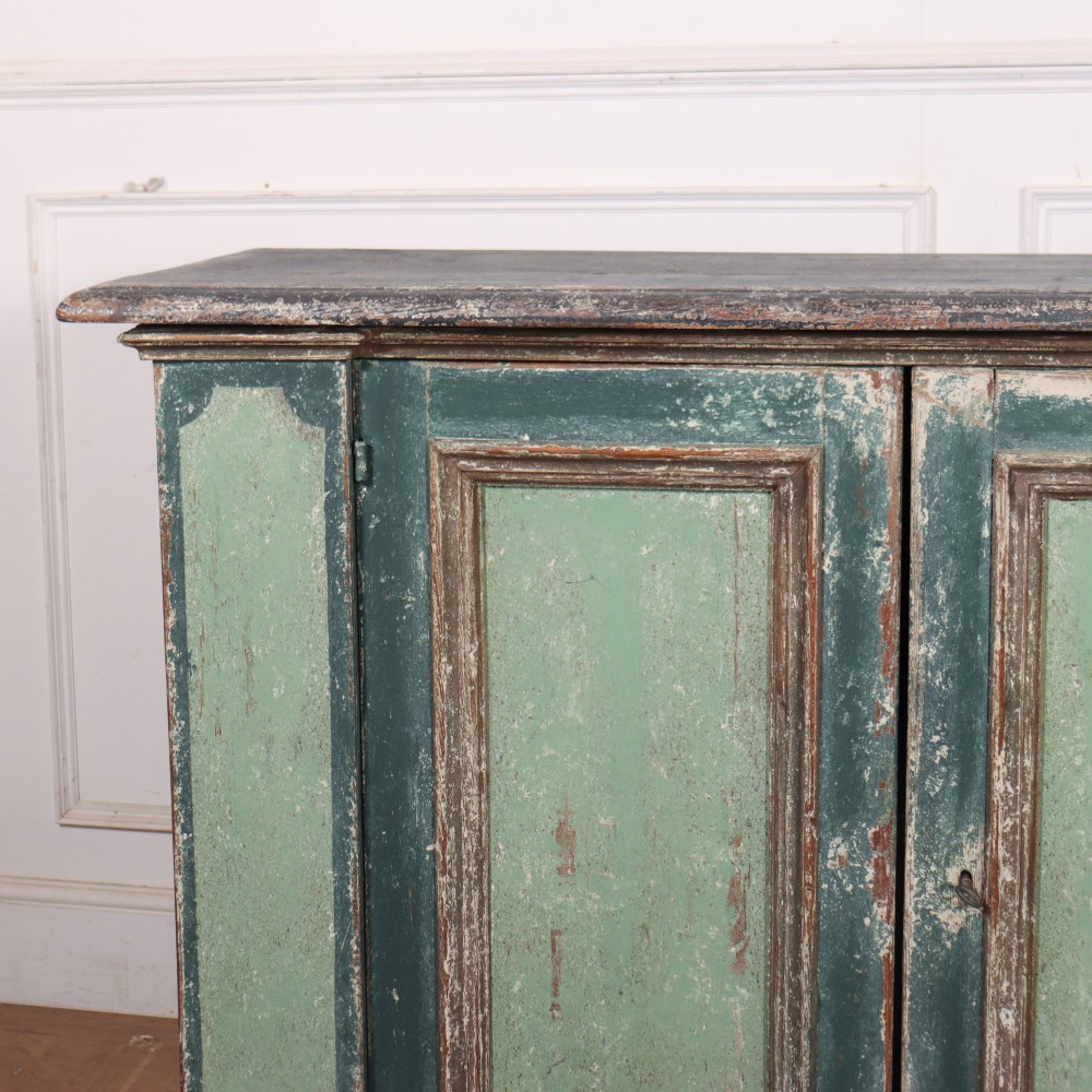 A long rectangular antique Italian side cabinet featuring four panelled doors in a distressed sage and teal painted finish with a plinth base. View II
