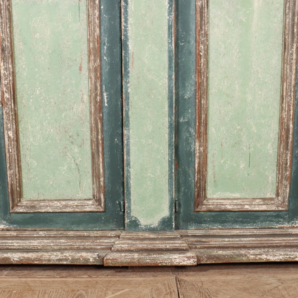 A long rectangular antique Italian side cabinet featuring four panelled doors in a distressed sage and teal painted finish with a plinth base. View IV