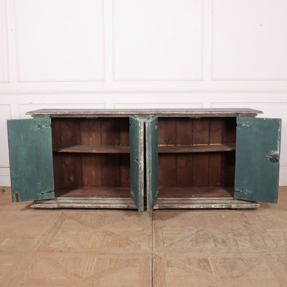 A long rectangular antique Italian side cabinet featuring four panelled doors in a distressed sage and teal painted finish with a plinth base. View VIII