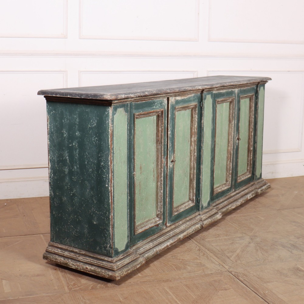 A long rectangular antique Italian side cabinet featuring four panelled doors in a distressed sage and teal painted finish with a plinth base. View XI