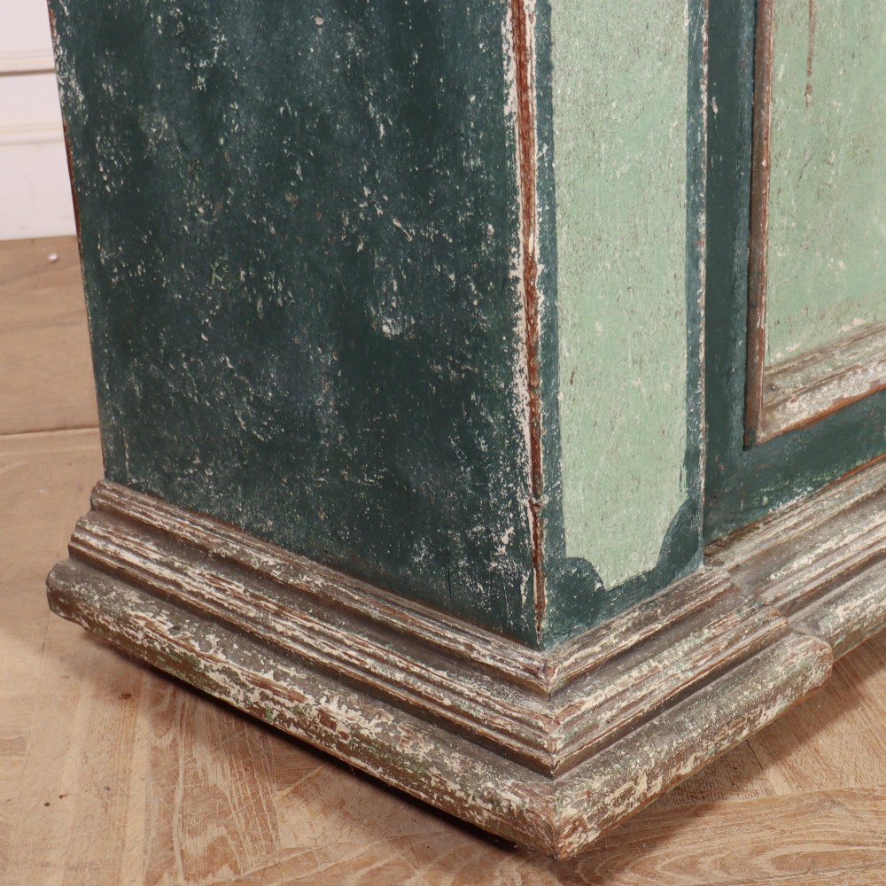 A long rectangular antique Italian side cabinet featuring four panelled doors in a distressed sage and teal painted finish with a plinth base. View XII