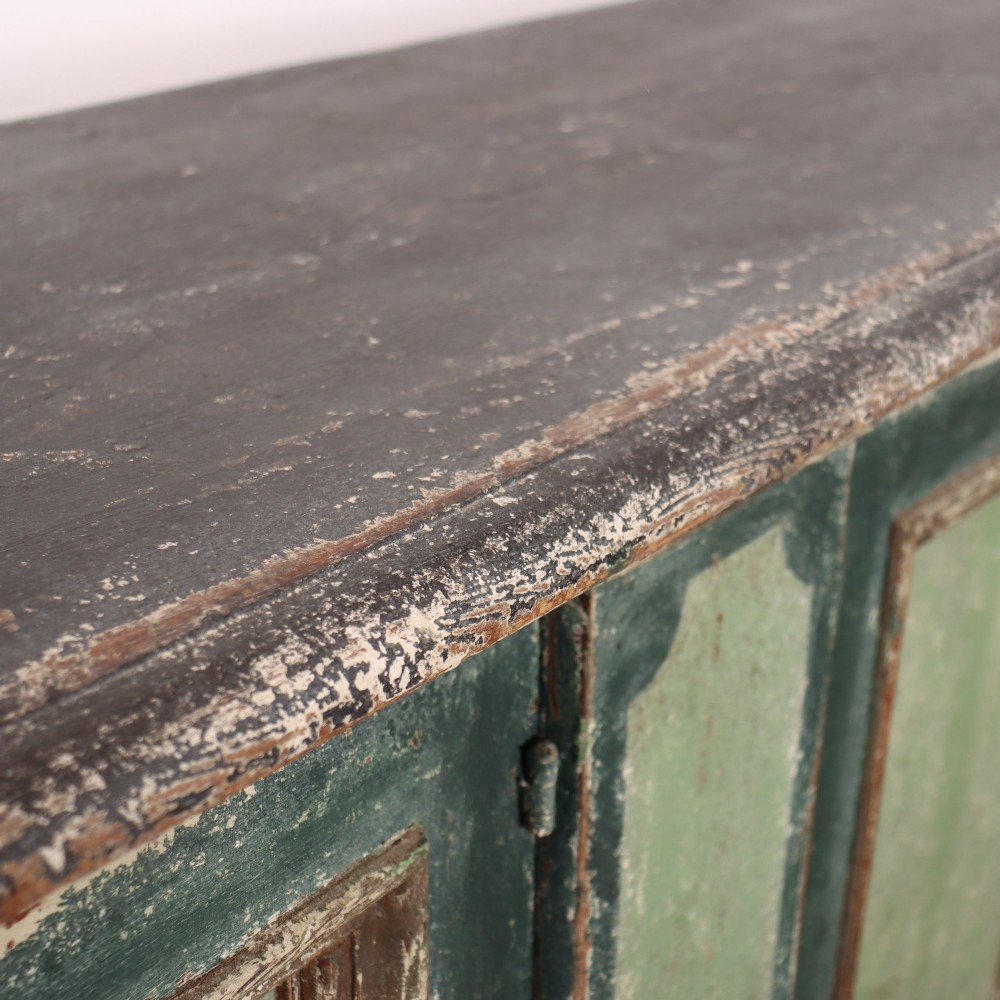 A long rectangular antique Italian side cabinet featuring four panelled doors in a distressed sage and teal painted finish with a plinth base. View XV