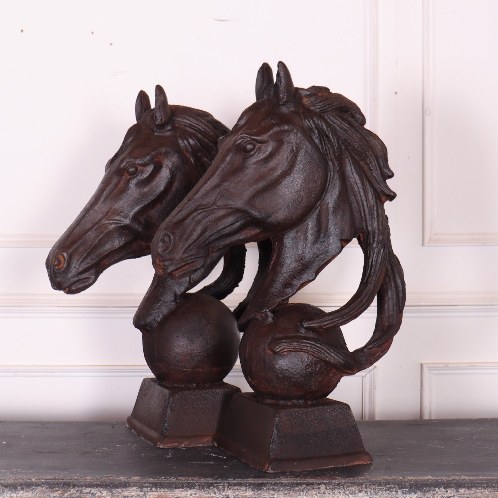 A pair of dark brown cast iron horse head sculptures mounted on spherical supports with square plinth bases. View II