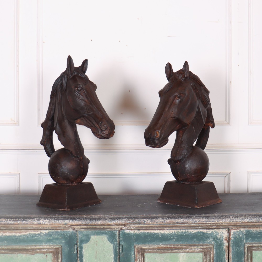 A pair of dark brown cast iron horse head sculptures mounted on spherical supports with square plinth bases. View III