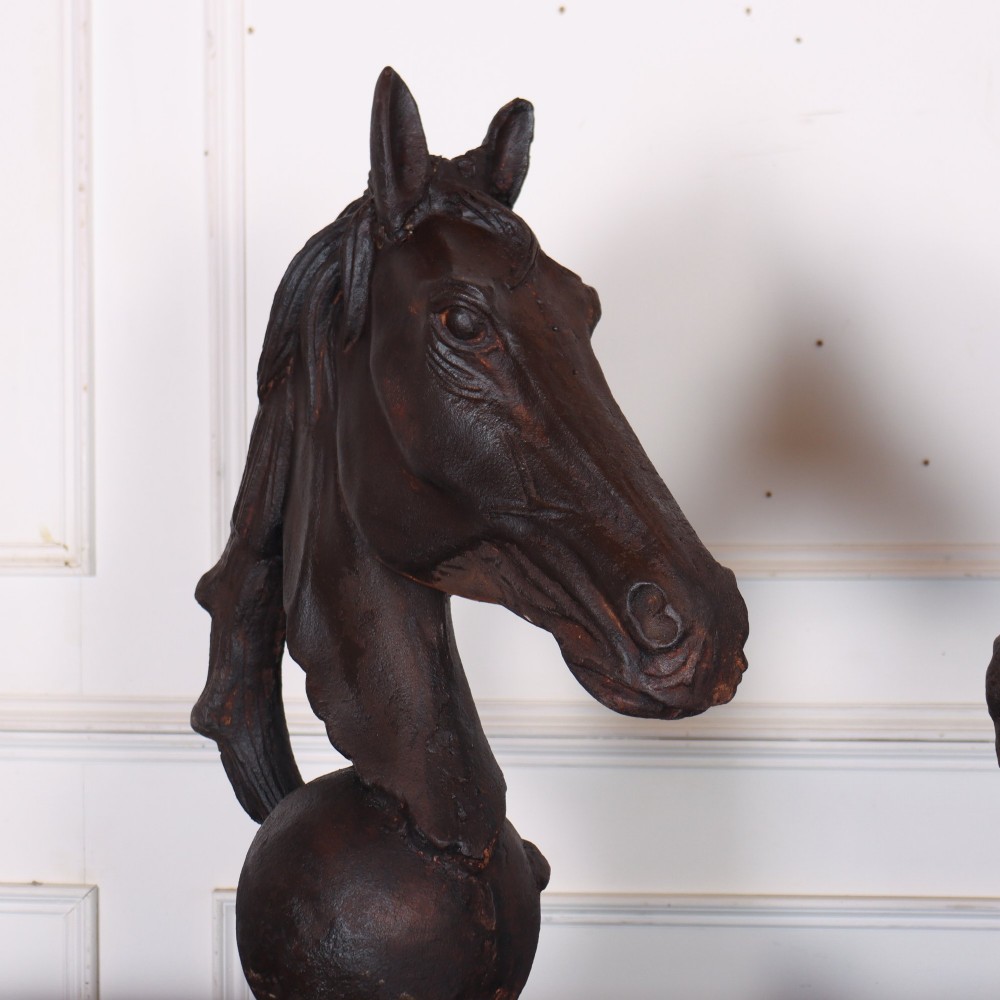 A pair of dark brown cast iron horse head sculptures mounted on spherical supports with square plinth bases. View IV