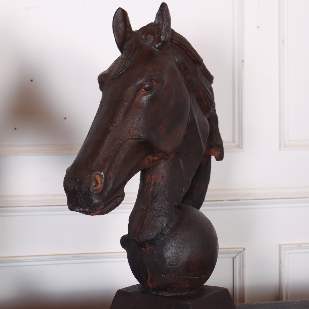 A pair of dark brown cast iron horse head sculptures mounted on spherical supports with square plinth bases. View V