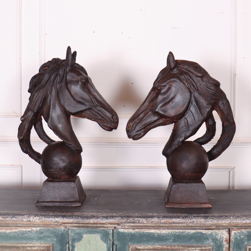 A pair of dark brown cast iron horse head sculptures mounted on spherical supports with square plinth bases. View VIII