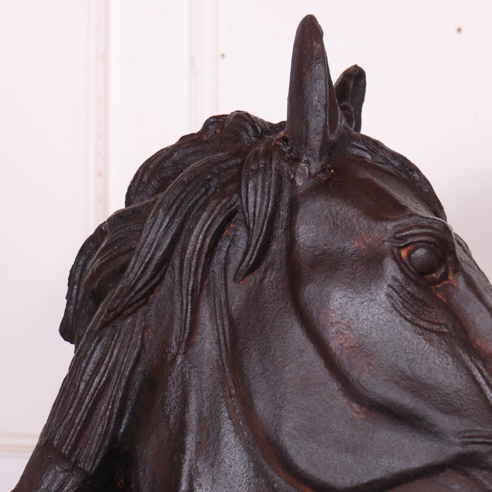 A pair of dark brown cast iron horse head sculptures mounted on spherical supports with square plinth bases. View IX