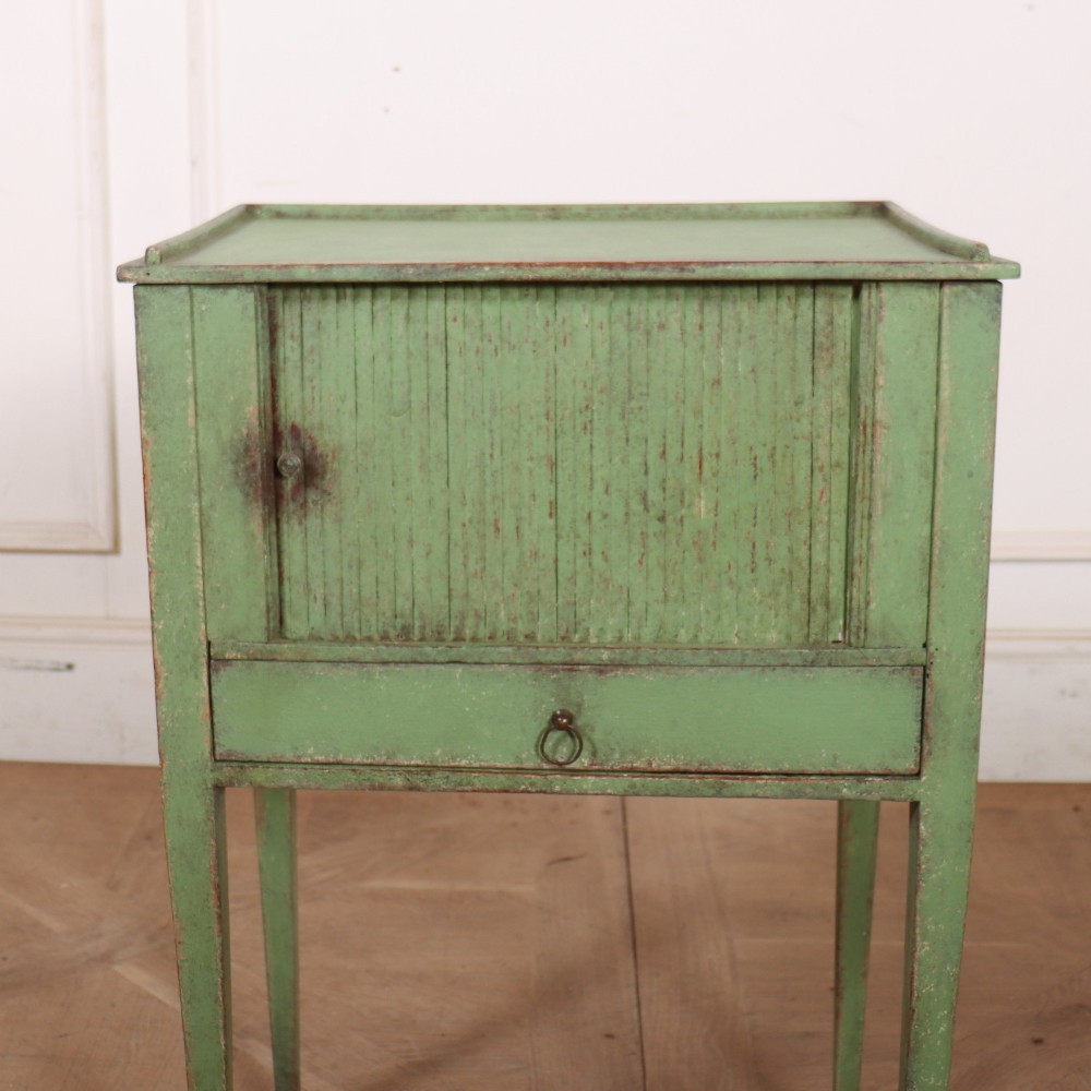 A Dutch provincial green painted bedside table with a slatted tambour door, lower drawer, and tapered square legs. View II