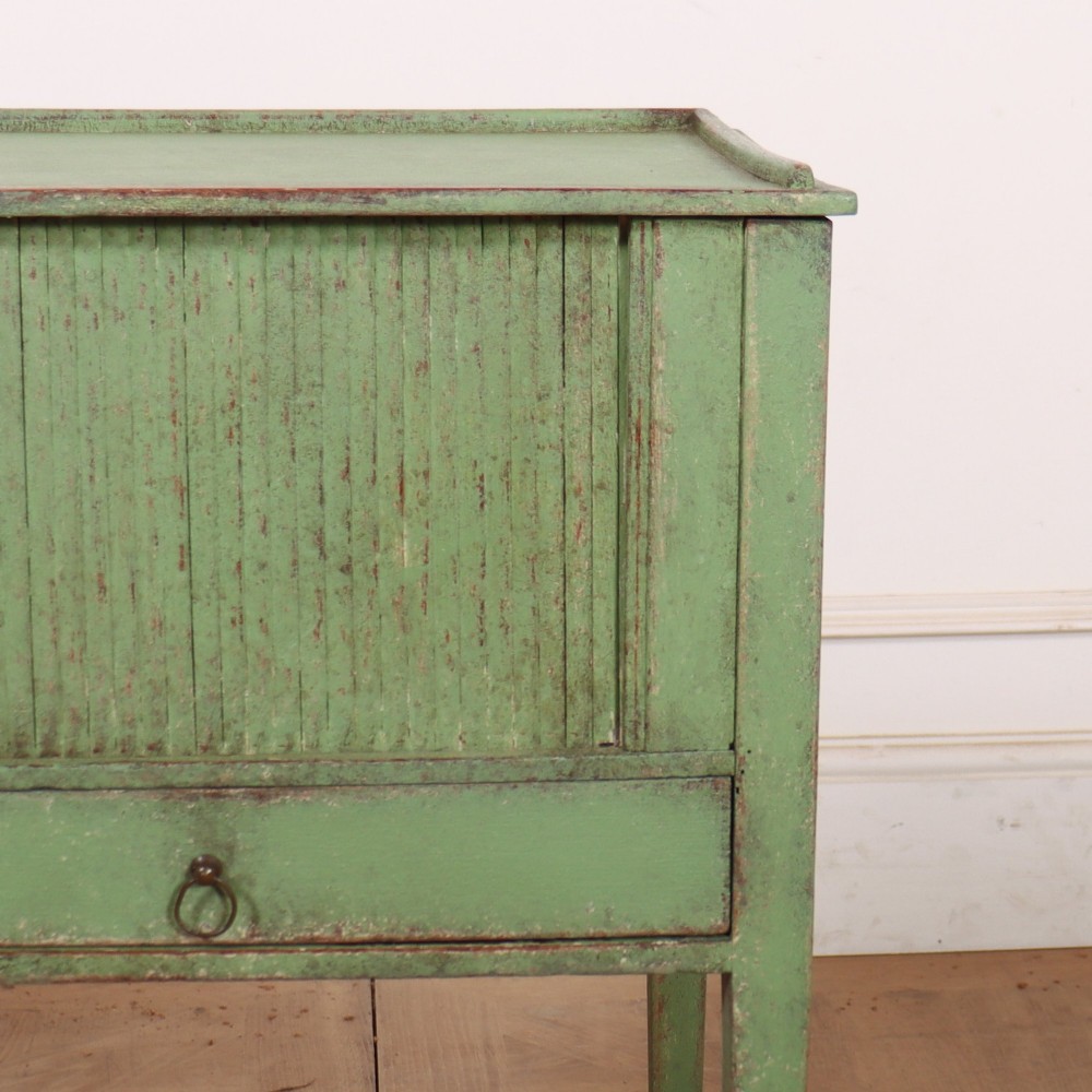 A Dutch provincial green painted bedside table with a slatted tambour door, lower drawer, and tapered square legs. View III
