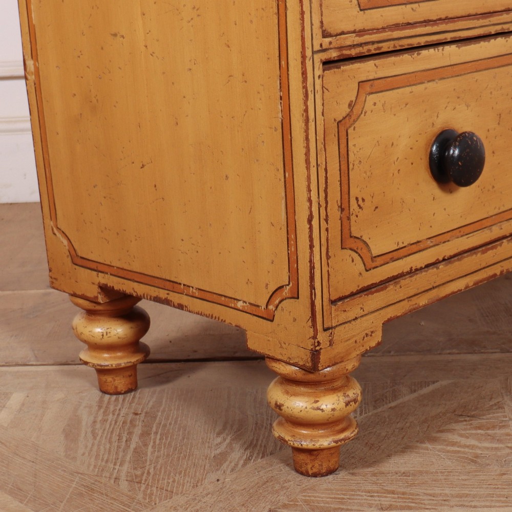 An antique yellow painted pine chest of drawers with two small drawers over three full-width drawers, featuring dark line border detailing, timber knobs, and turned feet. View VIII
