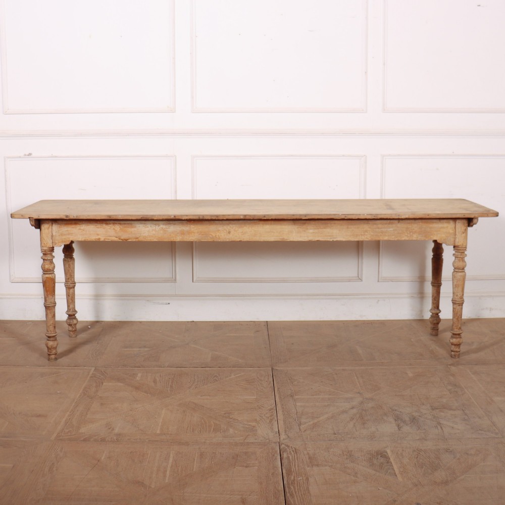 A long antique Italian painted wood farm table with turned legs and a distressed cream finish.