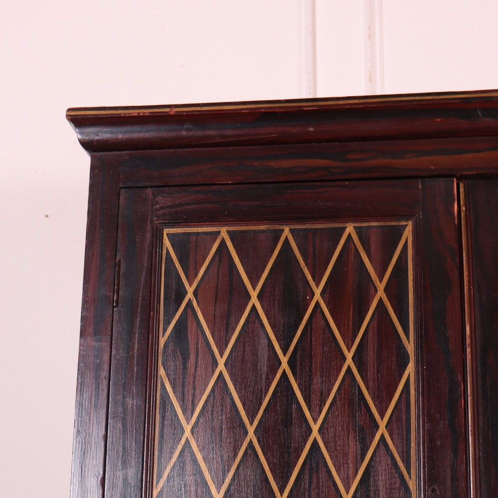 A tall 19th-century dark painted wooden cupboard with two tiers of double doors decorated with gold painted diamond lattice panels. View II