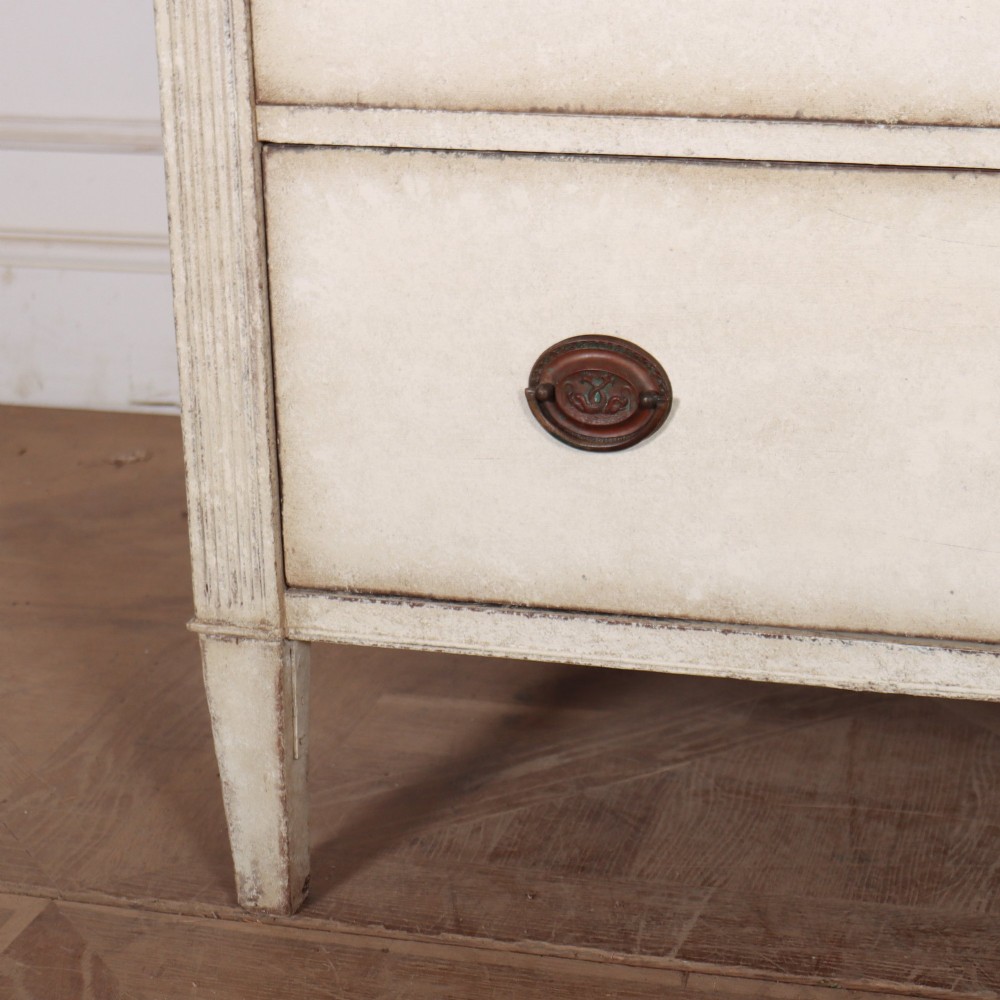 A tall off-white painted Scandinavian style linen cupboard featuring a two-door upper section above three drawers with circular brass handles. View VII