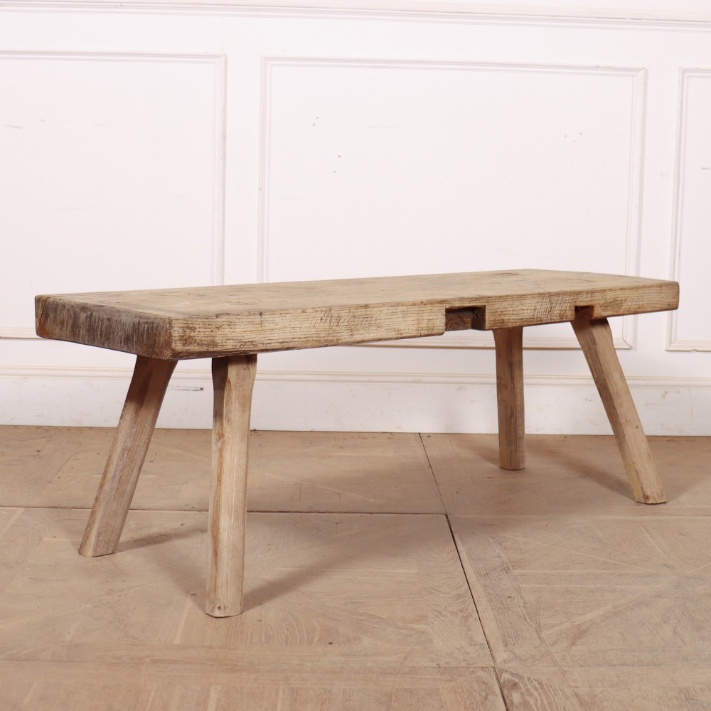 A low rectangular wooden coffee table crafted from thick timber with four splayed legs. View IV