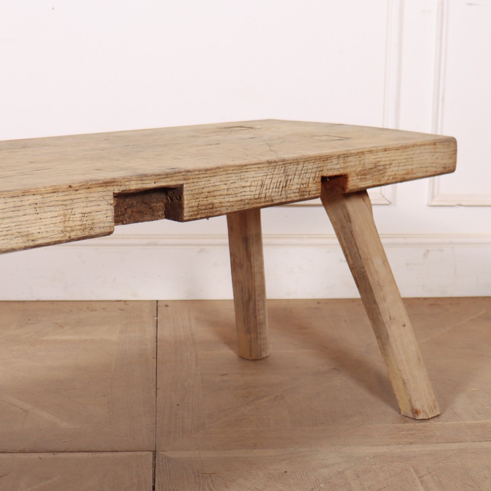A low rectangular wooden coffee table crafted from thick timber with four splayed legs. View V
